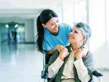 Gothaer Private Krankenversicherung: Pflegerin mit Frau im Rollstuhl